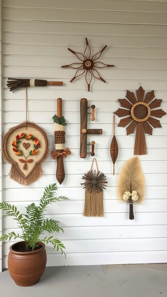 A variety of artistic wall hangings made from natural materials displayed on a white wall, with a potted plant in the foreground.